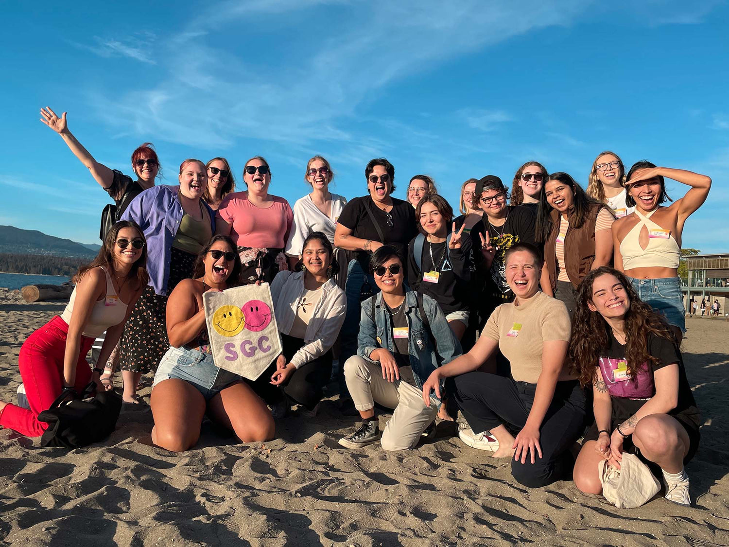 Sunny Beach Day with The Shy Girl Club meet up in Vancouver, smiling faces, large group and SGC flag held up